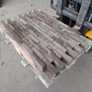 Pallet met jong gebruikte gebakken waaltjes in roodtint