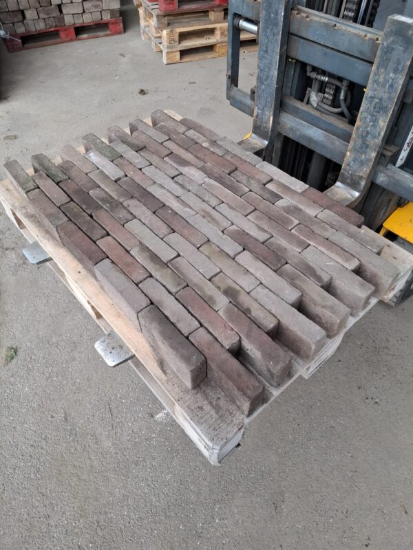 Pallet met jong gebruikte gebakken waaltjes in roodtint